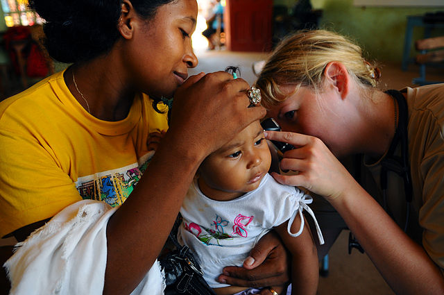 File:US Navy 080818-N-4515N-154 Air Force Capt. Amber Tyler, medical augmentee embarked aboard the amphibious assault ship USS Kearsarge (LHD 3), checks an infant for an ear infection at the Juan Comenius High School medical clinic.jpg